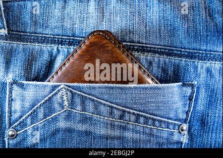 Leather wallet in jeans pocket. brown leather wallet Stock Photo