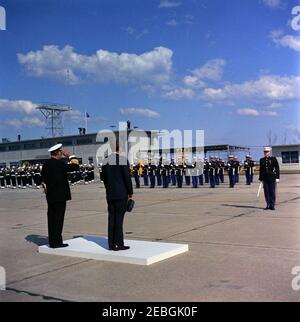 Visit to the Atlantic Fleet: Arrival at Oceana Naval Air Station, Virginia, 3:15PM. Standing on the reviewing platform with backs to camera, President John F. Kennedy (right, holding hat) and Admiral Robert L. Dennison, Commander in Chief of the Atlantic Command (CINCLANT), Commander in Chief of the U.S. Atlantic Fleet, and Supreme Allied Commander, Atlantic (SACLANT), observe U.S. Marine Corps honor guard troops during arrival ceremonies at Naval Air Station Oceana in Virginia Beach, Virginia. President Kennedy traveled to Virginia to begin a two-day visit to the U.S. Atlantic Fleet. Stock Photo
