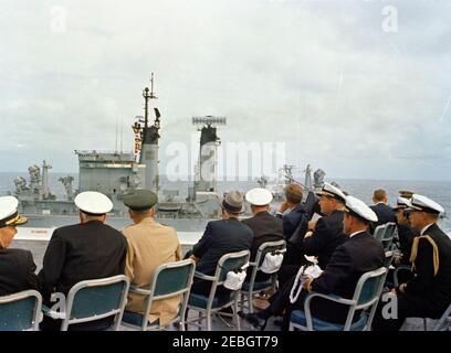 Trip to Western States: Visit to the Pacific Fleet, President Kennedy aboard the USS Kitty Hawk, 5:00PM. President John F. Kennedy (seated in high-back chair at right) and other distinguished guests watch U.S. Pacific Fleet demonstrations from the flight deck of the aircraft carrier USS Kitty Hawk (CVA-63), at sea off the coast of San Diego, California. Front row, left to right: Commander of the First Fleet, Vice Admiral Robert T. S. Keith; Chief of Naval Operations, Admiral George W. Anderson, Jr.; Chairman of the Joint Chiefs of Staff, General Maxwell D. Taylor; Secretary of the Navy Fred Ko Stock Photo
