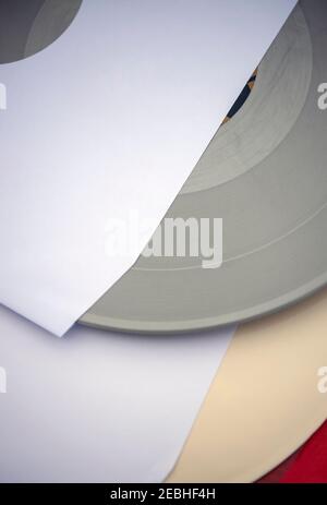 Silver coloured vinyl record in a white paper sleeve Stock Photo