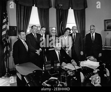 Bill signing - S. 1652, Amendment to the National Cultural Center Act , 12:00PM. President John F. Kennedy (seated at desk) signs a bill to amend the National Cultural Center Act. Looking on (L-R): General Counsel and member of the Board of Trustees for the National Cultural Center, Ralph E. Becker; Representative Robert E. Jones (Alabama); Representative James C. Wright, Jr. (Texas); Representative Charles A. Buckley (New York); Representative Charlotte T. Reid (Illinois); Chairman of the Board of Trustees for the National Cultural Center, Roger L. Stevens; and Representative Frank Thompson, Stock Photo