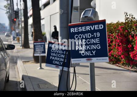 Los Angeles, CA USA - February 10, 2020: Parking meters near a hospital with signs saying reserved for Covid-19 vaccination patients only Stock Photo