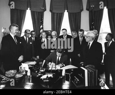 Bill signing - S. 2996 Public Law 87-565, Foreign Assistance Act, 10:29AM. President John F. Kennedy signs the Foreign Assistance Act, S. 2996 Public Law 87-565. Looking on (L-R): Senator John J. Sparkman (Alabama); Representative Wayne L. Hays of Ohio (mostly hidden); Representative Walter H. Judd of Minnesota (behind Representative Hays); Senator Everett Dirksen (Illinois); Representative Robert B. Chiperfield (Illinois); Senator Thomas H. Kuchel (California); Representative Francis E. Walter (Pennsylvania); Representative Thomas E. Morgan (Pennsylvania); Representative Peter Frelinghuysen, Stock Photo