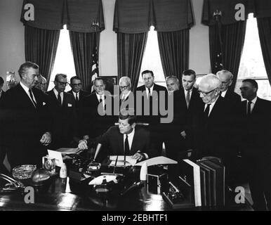 Bill signing - S. 2996 Public Law 87-565, Foreign Assistance Act, 10:29AM. President John F. Kennedy signs the Foreign Assistance Act, S. 2996 Public Law 87-565. Looking on (L-R): Senator John J. Sparkman (Alabama); Representative Wayne L. Hays of Ohio (mostly hidden); Representative Walter H. Judd of Minnesota (in back); Senator Everett Dirksen (Illinois); Representative Robert B. Chiperfield (Illinois); Senator Thomas H. Kuchel (California); Representative Francis E. Walter (Pennsylvania); Representative Thomas E. Morgan (Pennsylvania); Representative Peter Frelinghuysen, Jr. (New Jersey); R Stock Photo