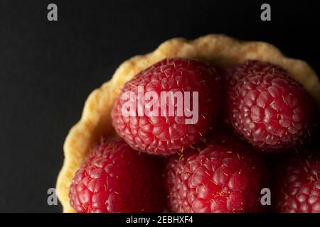 Raspberry tart, top view macro photography. Homemade raspberry tart on the black background. Stock Photo