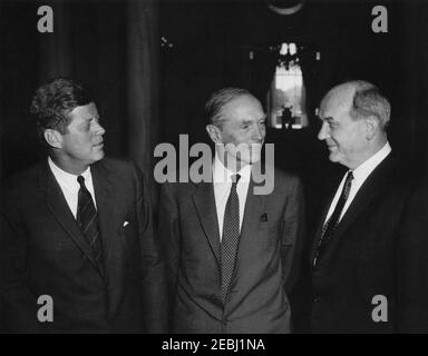 Luncheon in honor of Lord Alec Douglas-Home, Foreign Secretary of Great Britain, 1:00PM. President John F. Kennedy visits with Secretary of State for Foreign Affairs of Great Britain and Earl of Home, Alec Douglas-Home; Lord Home visited the White House to attend a luncheon in his honor. Left to right: President Kennedy; Lord Home; U.S. Secretary of State, Dean Rusk. Entrance Hall of the White House, Washington, D.C.