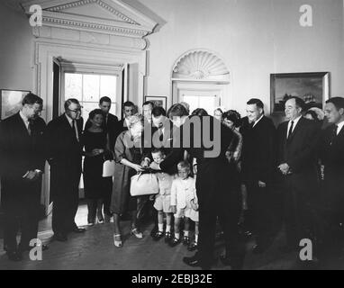 Presentation of the Thomas A. Dooley III Medal to Mrs. Agnes Dooley, 10:04AM. President John F. Kennedy presents the posthumous Dr. Thomas A. Dooley III Congressional Gold Medal to Dr. Dooleyu2019s mother, Agnes Wise Dooley (center left). Also pictured: Executive Director of Medical International Cooperation Organization (MEDICO), Malcolm W. Dooley, and Gabrielle Dooley and their children, Malcolm Jr., Thomas, and Michael; Representative Henry S. Reuss (Wisconsin); Senator John A. Carroll (Colorado); Director of the U.S. Mint, Eva Adams; Senator Claiborne Pell (Rhode Island); Representative F Stock Photo