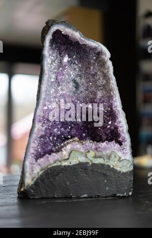 Big amethyst mineral stone on slate worktop. Stock Photo