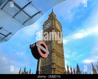 London, United Kingdom - January 29, 2007: Underground Sign Pole and Big Ben Tower in London, UK. Stock Photo