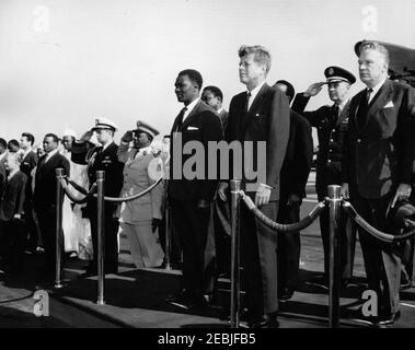 Arrival ceremony for Ahmed Su00e9kou Touru00e9, President of Guinea, 11:00AM. Arrival ceremonies for President of Guinea, Ahmed Su00e9kou Touru00e9. Standing on reviewing platform (L-R): President Touru00e9; Minister of Foreign Affairs of Guinea, Louis Lansana Bu00e9avogui (in back, partially hidden); President John F. Kennedy; Ambassador of Guinea, Dr. Seydou Conte (in back, mostly hidden); Chairman of the Joint Chiefs of Staff, General Maxwell D. Taylor; U.S. Under Secretary of State, George Ball. Standing left of platform: Naval Aide to President Kennedy, Captain Tazewell T. Shepard,