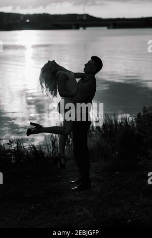 Silouette, loving couple on the lake during sunset Stock Photo