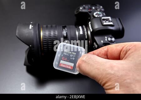 St. Petersburg, Russia - January 9, 2021: Close-up hand holds SanDisk extreme PRO 64GB SDXC memory card up to 170MB / s, class 10, U3, V30 for camera. Stock Photo
