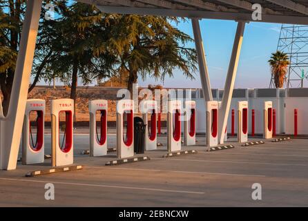 Firebaugh, USA - January 21, 2021: Rows of empty electric Tesla superchargers by California Highway 5 Stock Photo