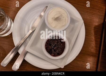 over head view of cream cheese and jam, with two knives served on a cafeteria platter Stock Photo