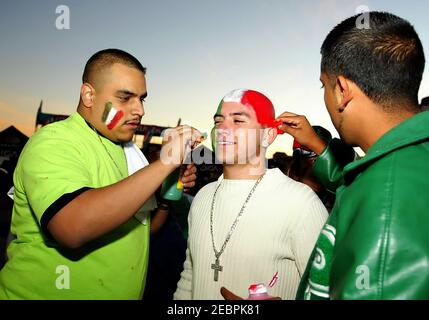 Mexican soccer hands have their face painted in the national colors Stock Photo