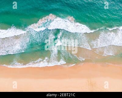 Aerial view top view Beautiful topical beach with white sand coconut palm trees and sea. Top view empty and clean beach. Waves crashing empty beach fr Stock Photo