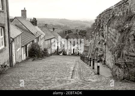 Gold Hill is a steep cobbled street in the town of Shaftesbury in the English county of Dorset. The view looking down from the top of the street has b Stock Photo