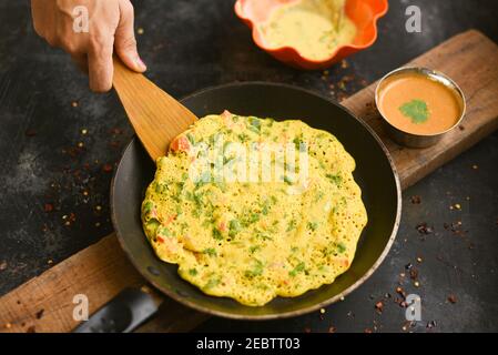 Whole wheat Dosa , goduma dosa or Crepes, uttapam with Tomato Chutney or coconut chutney Kerala breakfast food. Woman hand making dosa. South Indian, Stock Photo