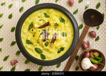 Bowl of homemade sour cream curd yogurt Dahi fresh herbs curry leaf Kerala, India. Dairy product obtained by coagulating milk a process curdling. Stock Photo