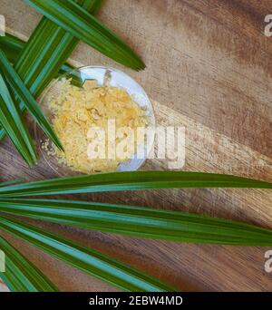 Organic Candelilla Wax in Chemical Watch Glass and broadleaf lady palm leaf  on wooden background. (Top View Stock Photo - Alamy