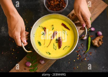 Bowl of homemade sour cream curd yogurt Dahi fresh herbs curry leaf Kerala, India. Dairy product obtained by coagulating milk a process curdling. Stock Photo