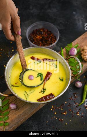 Bowl of homemade sour cream curd yogurt Dahi fresh herbs curry leaf Kerala, India. Dairy product obtained by coagulating milk a process curdling. Stock Photo