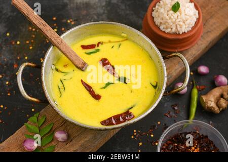 Bowl of homemade sour cream curd yogurt Dahi fresh herbs curry leaf Kerala, India. Dairy product obtained by coagulating milk a process curdling. Stock Photo