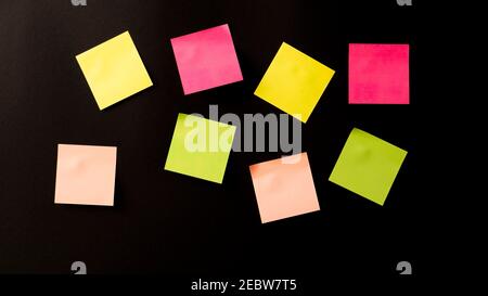 lots of colored stickers on a black background. stickers on the wall Stock Photo