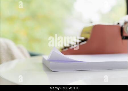Pile of blank paper and typewriter Stock Photo