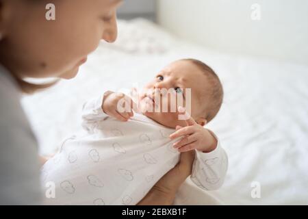 Pretty baby boy on mother hands in room closeup. Motherhood. Childhood.  Stock Photo
