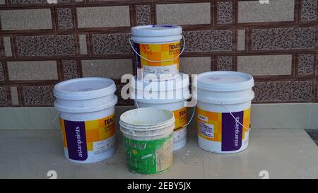 08 February 2021- Khatoo, Jaipur, India. Paint cans and color palette samples in bucket. Plastic color buckets holding upon each other with grey marbl Stock Photo