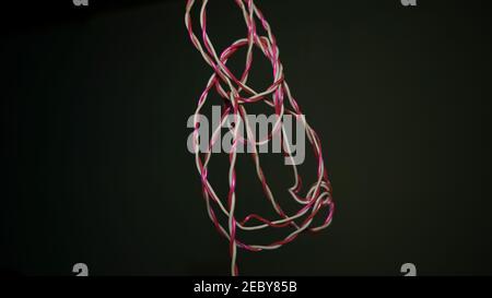 Electrical electric cable wires closeup. White and red earth wires free moving and hanging from rooftop. Stock Photo