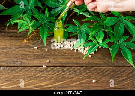 CBD hemp oil, Hand holding bottle of Cannabis oil in pipette. Stock Photo