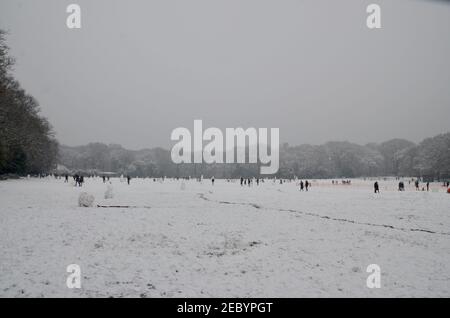 families and people building snowmen and walking in the snow in highgate woods london england uk 2021 Stock Photo