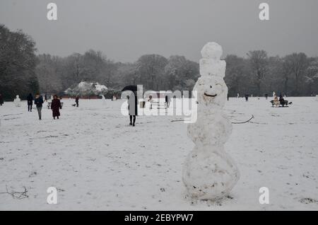families and people building snowmen and walking in the snow in highgate woods london england uk 2021 Stock Photo