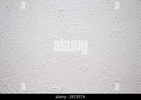 Painted wall with rough texture closeup photo. White plaster with brushed texture. White house wall. Greek architecture background. Pottery house wall Stock Photo