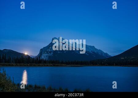 Moonrise at Vermilion Lakes in summer night. Banff National Park, Canadian Rockies, Alberta, Canada. Bright full moon over Mount Rundle Stock Photo