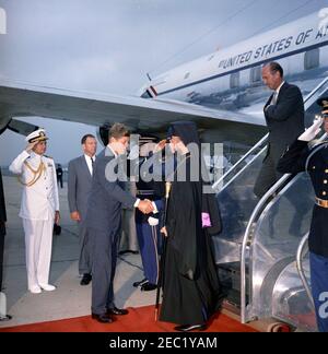 Arrival ceremony for Archbishop Makarios III, President of Cyprus, 11:00AM. President John F. Kennedy (center left) shakes hands with President of the Republic of Cyprus, Archbishop Makarios III, upon the Archbishopu0027s arrival at Washington National Airport. Naval Aide to President Kennedy, Captain Tazewell T. Shepard, Jr. (saluting), and U.S. Assistant Chief of Protocol for Visits and Public Events, Samuel L. King, stand at left. U.S. Chief of Protocol, Angier Biddle Duke, walks down airplane stairs. Military Air Transport Service (MATS) terminal, Washington National Airport, Washington D Stock Photo