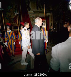 Trip to Europe: Vatican City: President Kennedy at the Vatican. Jean Kennedy Smith, Secretary of State Dean Rusk, and Press Secretary Pierre Salinger, 10:00AM. U.S. Secretary of State, Dean Rusk, walks through Clementine Hall of the Apostolic Palace during President John F. Kennedyu2019s visit to the Vatican to meet with Pope Paul VI. Naval Aide to President Kennedy, Captain Tazewell T. Shepard, Jr., walks at left. Members of the Swiss Guard observe. Vatican City. Stock Photo