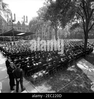 Trip to New York and Connecticut: Commencement Address at Yale University, 11:30AM. Wide-view of the Old Campus at Yale University during commencement exercises; President John F. Kennedy (seated on stage, in background) delivered the commencement address and received an honorary degree as part of the ceremony. Durfee Hall is visible at left in background. New Haven, Connecticut. [Photograph by Harold Sellers] Stock Photo