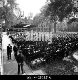 Trip to New York and Connecticut: Commencement Address at Yale University, 11:30AM. Wide-view of the Old Campus at Yale University during commencement exercises; President John F. Kennedy (seated on stage, in background) delivered the commencement address and received an honorary degree as part of the ceremony. Durfee Hall is visible at left in background. New Haven, Connecticut. [Photograph by Harold Sellers] Stock Photo