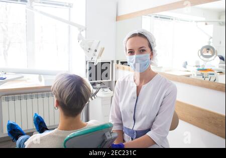 Portrait of female dentist. She standing and smiling with arms crossed in her dentist office Stock Photo