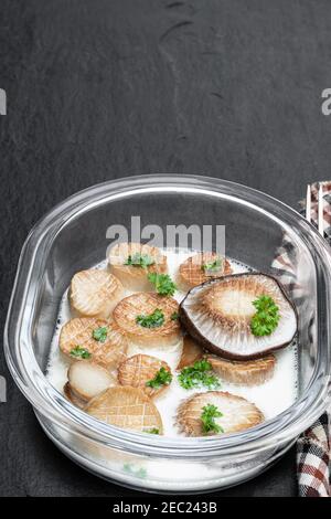 King  oyster mushroom scallops with cream sauce on black stone background Stock Photo