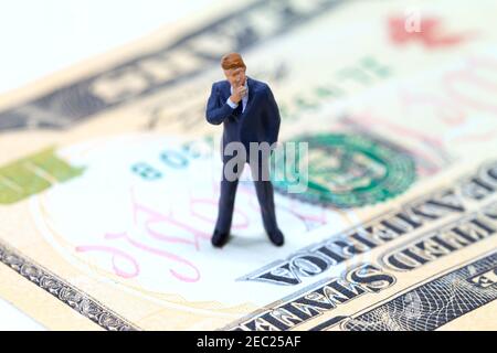 Businessman figurine on usa dollar banknote. Business standing on money concept. Modern economics and financial growth. Thinking businessman. Profitab Stock Photo