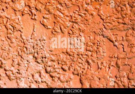 Rough red painted concrete wall. Bright rough plaster photo texture. Shabby chic backdrop. Old concrete surface with stains. Distressed texture in war Stock Photo