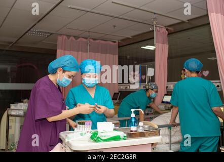 (210213) -- URUMQI, Feb. 13, 2021 (Xinhua) -- Midwives Wang Lingling (2nd L) and Gulnigar Abuduresuli (1st L) check the information of blood samples at the maternity ward of Urumqi Maternal and Child Health Hospital in Urumqi, northwest China's Xinjiang Uygur Autonomous Region, Feb. 12, 2021. With advanced equipment and sufficient personnel, Urumqi Maternal and Child Health Hospital has one of the most popular maternity wards in the region.Medical workers here stick to their posts during the Spring Festival vacation. To better control and prevent the COVID-19 pandemic, negative nucleic acid te Stock Photo