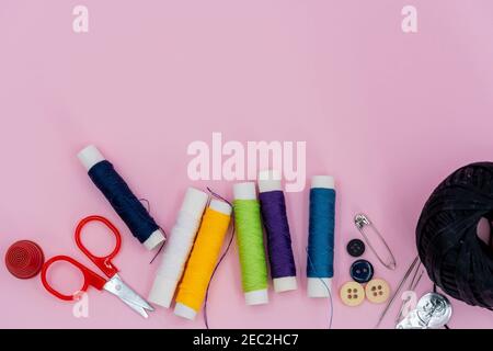 Sewing background. Accessories for needlework on wooden background. Spools of thread, scissors, buttons, measuring tape, sewing supplies. Set for need Stock Photo