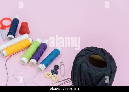 Sewing background. Accessories for needlework on wooden background. Spools of thread, scissors, buttons, measuring tape, sewing supplies. Set for need Stock Photo