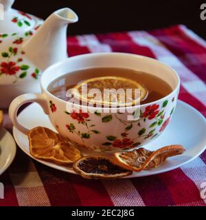 Cup of tea served with dried slices of lemons on the table Stock Photo
