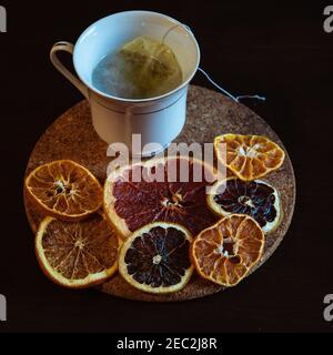 Cup of tea served with dried slices of lemons on a wooden board Stock Photo
